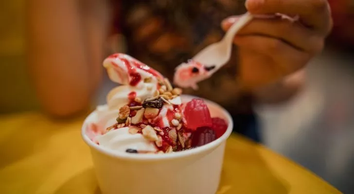 A person eating a frozen yogurt with a spoon