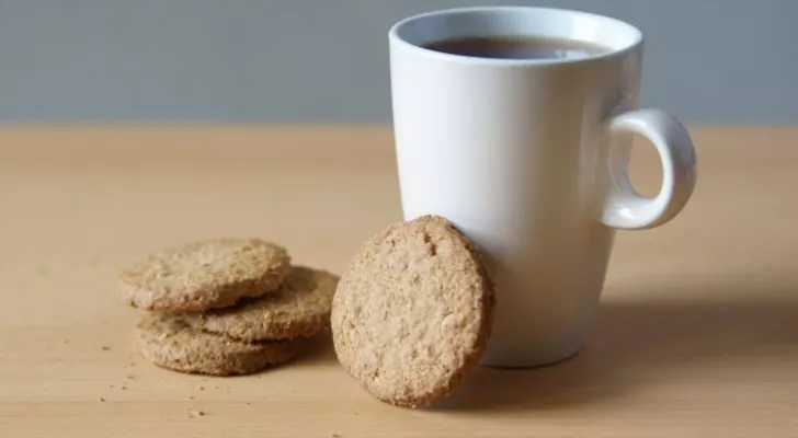 A cup of coffee with some biscuits