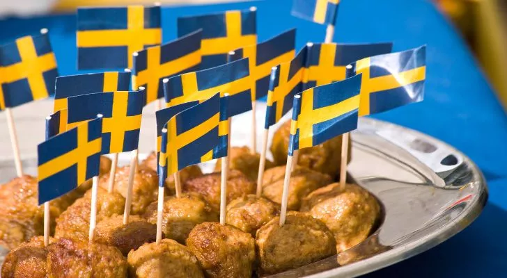 A plate of meatballs with miniature Swedish flags