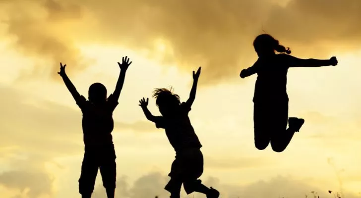 The silhouettes of several children jumping in the air