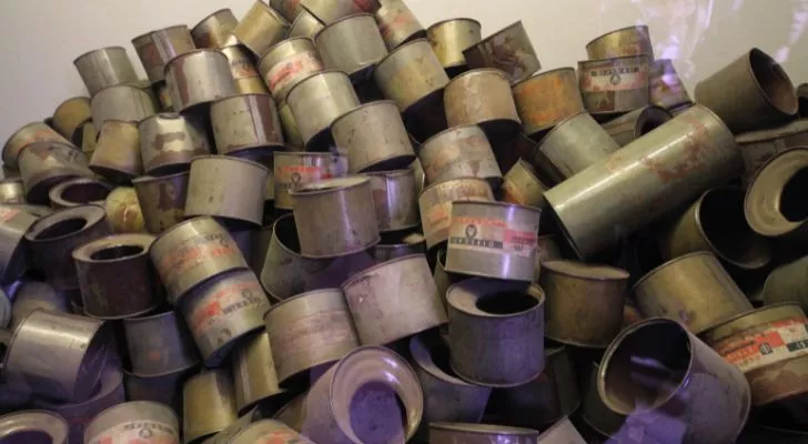 A huge collection of old Zyklon B canisters piled on top of each other