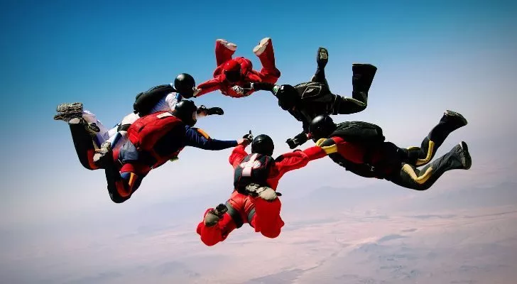 A group of friends skydiving in a circle