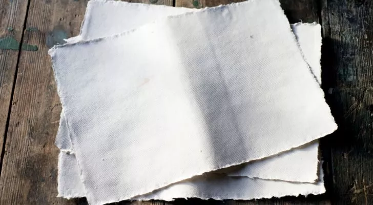 A stack of thick, white sheets of recycled paper