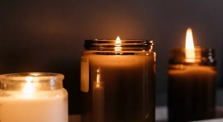 Several lit candles in various glass jars