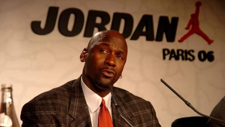 Michael Jordan speaking at a press event with "Jordan Paris 06" logo in the background