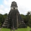Ancient Maya pyramid in Tikal surrounded by dense greenery showcasing architectural grandeur