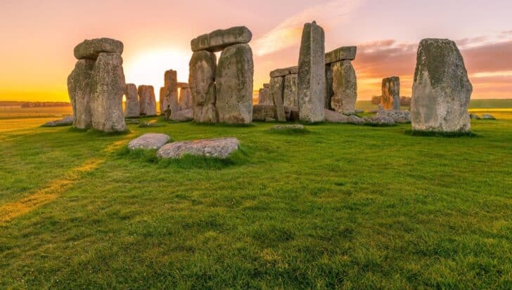 Stonehenge at sunset, a prehistoric monument in England with large standing stones on a grassy field