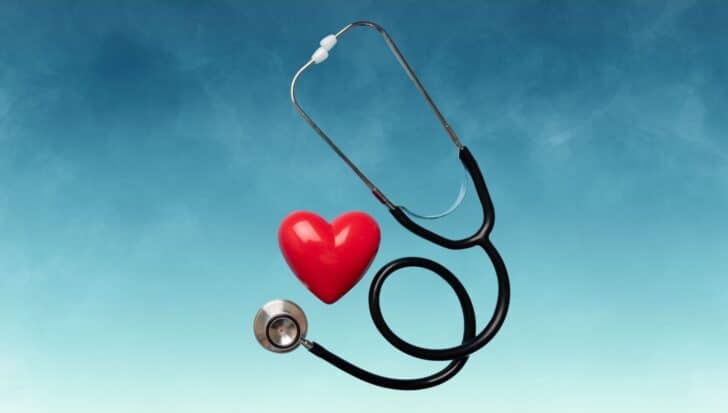 Stethoscope and red heart against a blue background representing health care themes