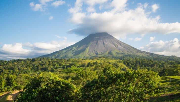 A large volcano surrounded by lush greenery, illustrating the fertile land around it