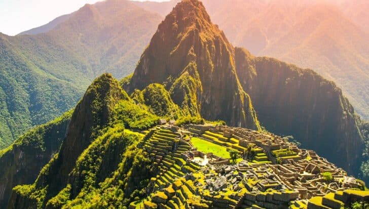 Scenic view of Machu Picchu, an iconic ancient Incan city surrounded by lush green mountains and a popular tourist destination in Peru