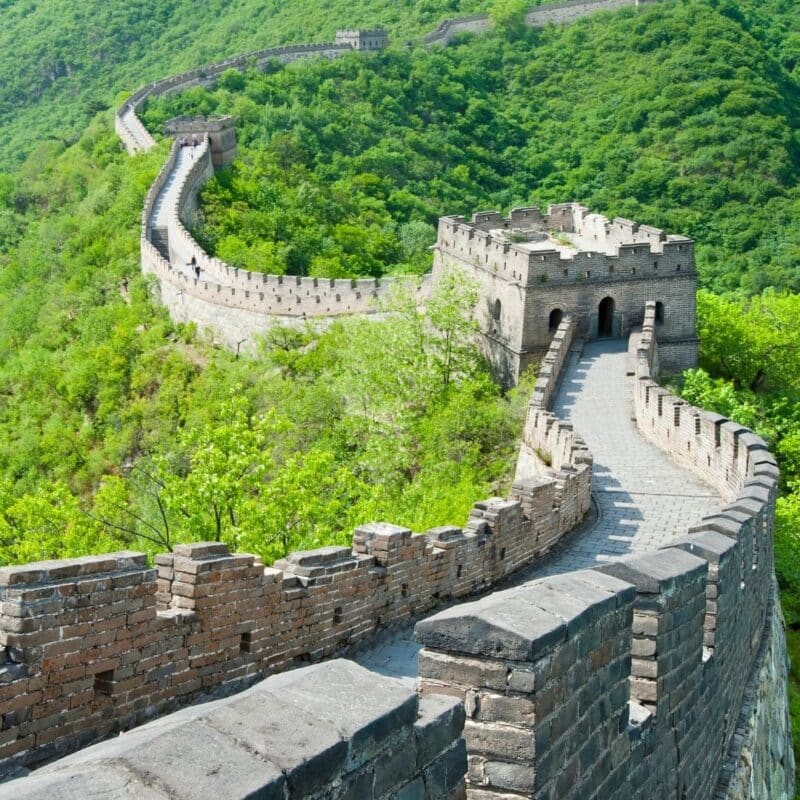 The Great Wall of China winding through lush green hills on a clear day