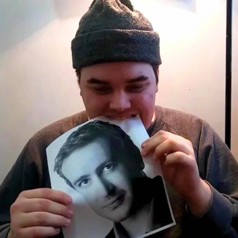 Person wearing a beanie biting a printed photo of Jason Segel
