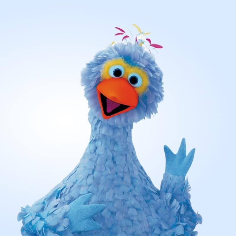 Pino, a blue bird from the Netherlands' version of Sesame Street, with colorful feathers and a cheerful expression