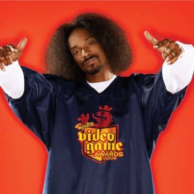 Snoop Dogg posing in front of a bright red background