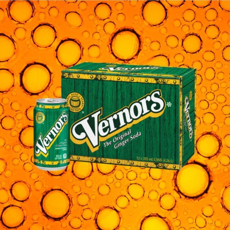 Vernors Ginger Ale can and 12-pack box against a vibrant orange background with bubbles