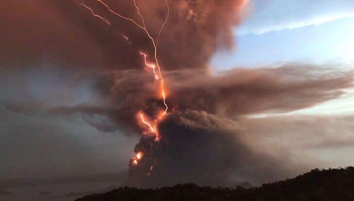 Volcanic eruption with dark ash clouds and visible lightning