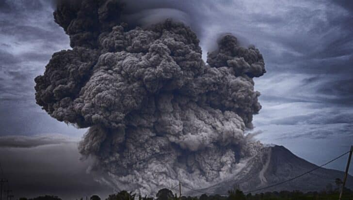 Large volcanic eruption with massive cloud of ash and smoke billowing into the sky, demonstrating how volcanoes can impact weather