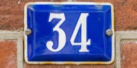 Blue enamel sign with the number 34 mounted on a brick wall