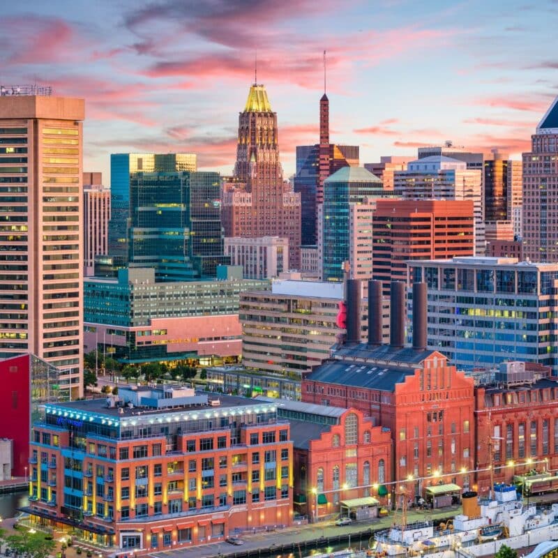 Baltimore skyline featuring a mix of modern and historic buildings at sunset
