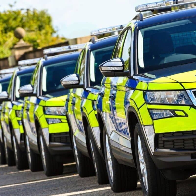 A row of parked Belfast police SUVs with reflective yellow and blue markings