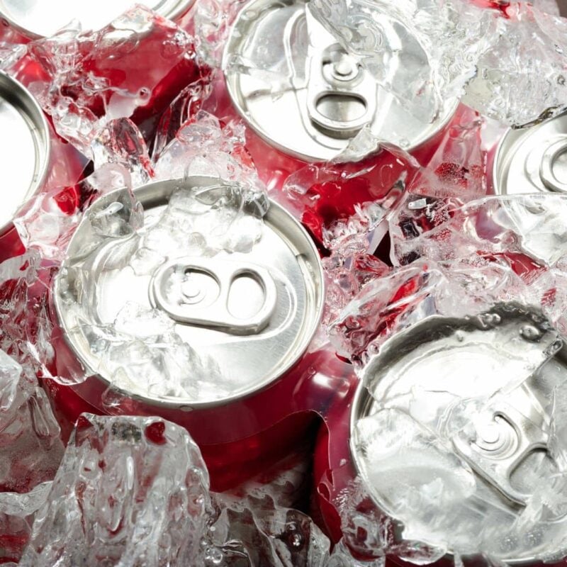 Red Coca-Cola cans surrounded by ice