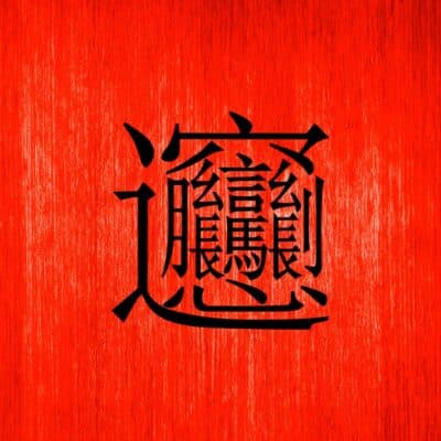 The intricate Chinese character "biáng" on a red wooden background