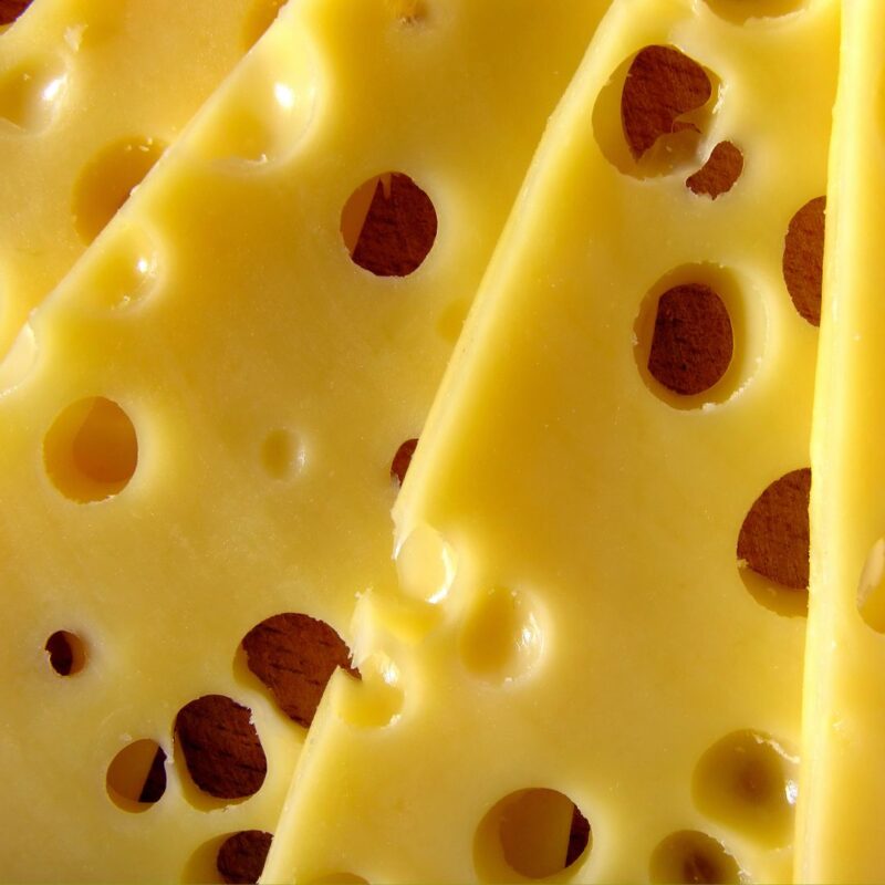 Close-up of sliced Swiss cheese with characteristic holes