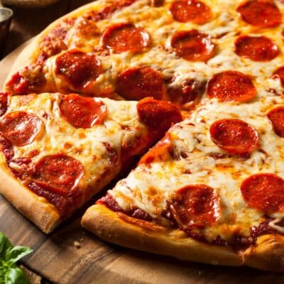 Pepperoni pizza with melted cheese on a wooden board