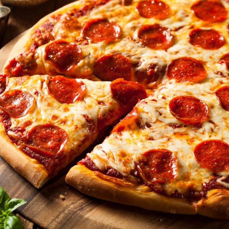 Pepperoni pizza with melted cheese on a wooden board