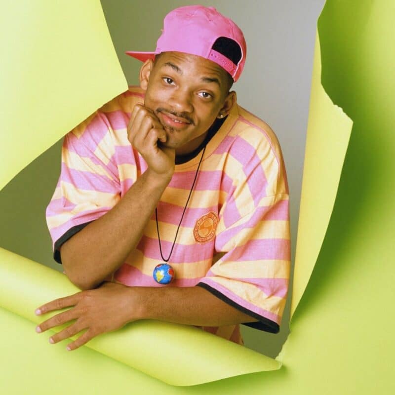 Will Smith wearing a pink and yellow striped shirt and pink cap