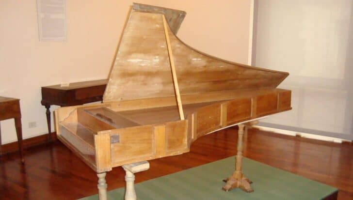An original Cristofori piano displayed in a museum setting, showcasing the historical design of one of the three remaining pianos created by Bartolomeo Cristofori