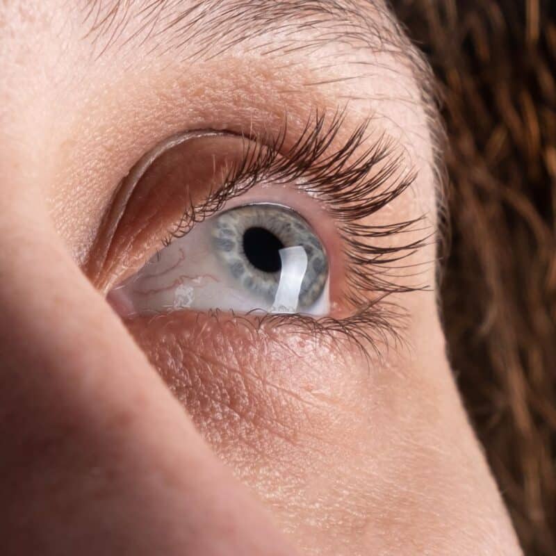 Close-up of a human eye, highlighting the cornea and surrounding eyelashes