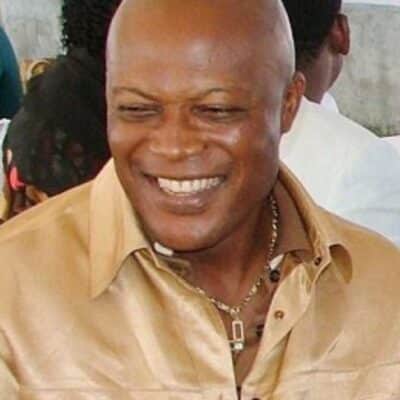 Emmanuel Nwude smiling, wearing a golden shirt