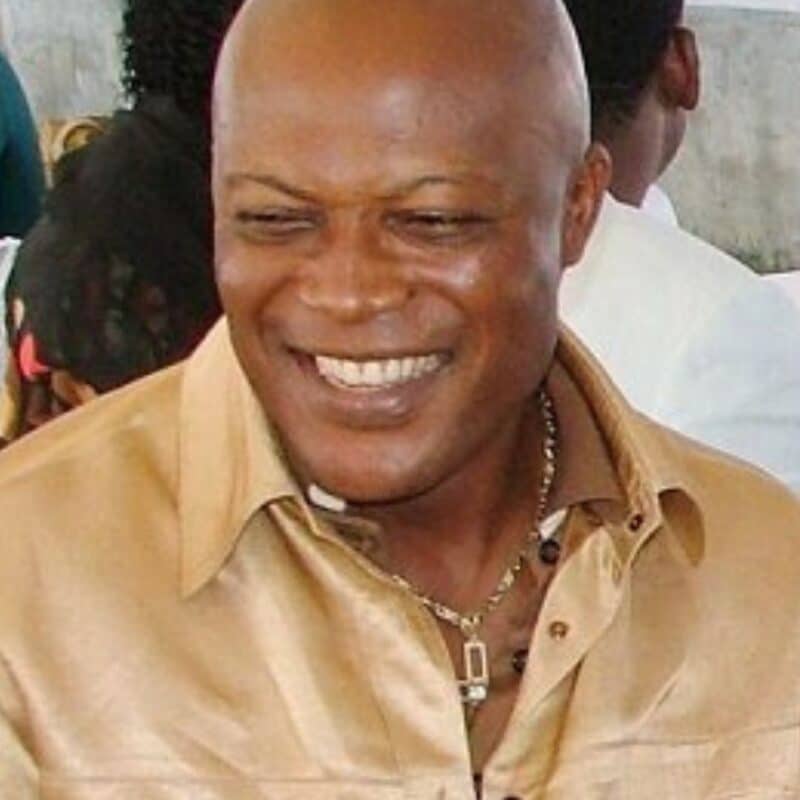 Emmanuel Nwude smiling, wearing a golden shirt