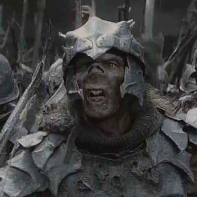 An Orc from The Lord of the Rings wearing detailed, weathered armor and a helmet with jagged edges