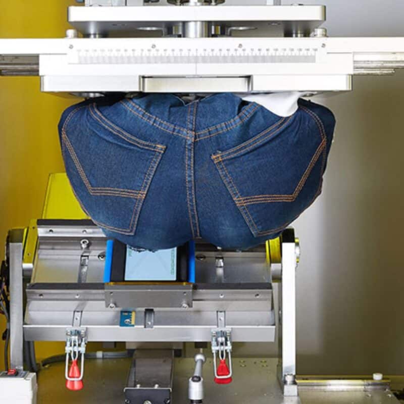 A robotic device wearing jeans simulates sitting on a Samsung phone to test its durability