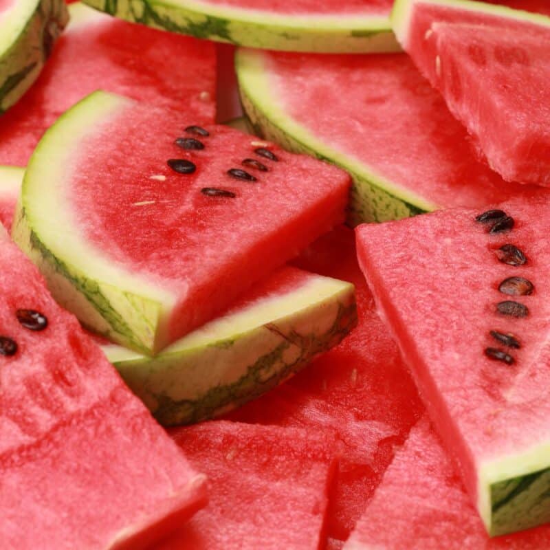 Slices of ripe watermelon with green rinds and black seeds