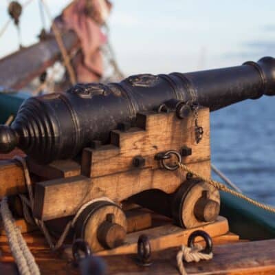 Cannon on a wooden ship's deck, positioned to fire heated cannonballs