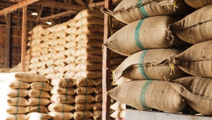 Stacks of large burlap sacks filled with rice in a warehouse