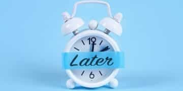 A white alarm clock against a blue background with a blue banner across the clock face displaying the word 'Later'
