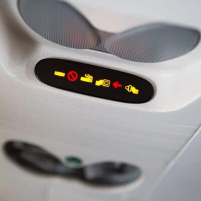 Illuminated airplane signs showing no smoking and fasten seatbelt warnings