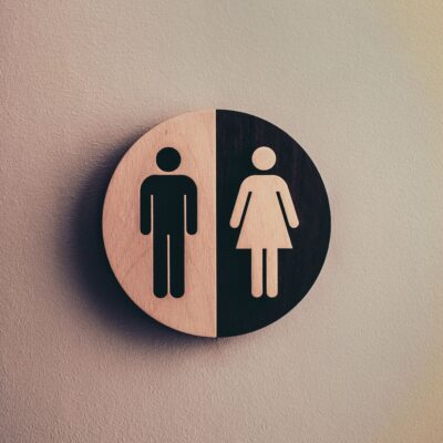 Wooden restroom sign showing male and female symbols