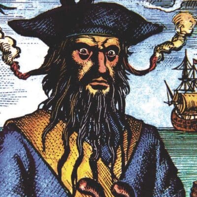 Illustration of Blackbeard with a burning fuse in his hat, ship in background