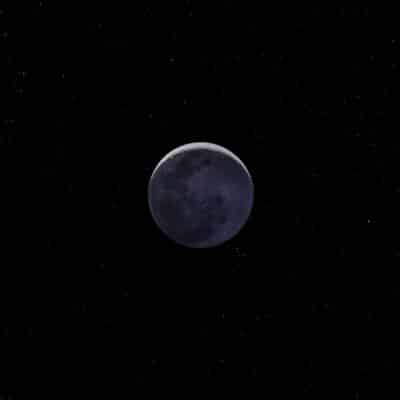 The Moon's far side is visible in space against a starry background