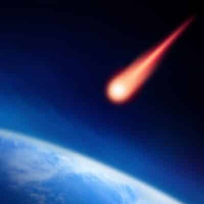 Fiery meteoroid streaking through dark sky toward Earth