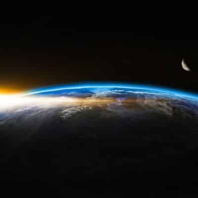 Earth's curved horizon with atmospheric glow and a distant moon