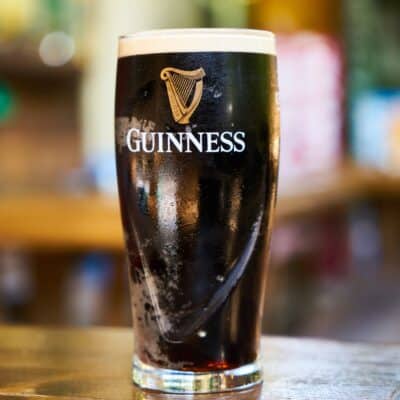 Pint glass of Guinness with dark stout and creamy head