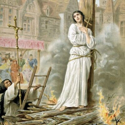 Joan of Arc tied to a stake surrounded by flames, onlookers seated behind
