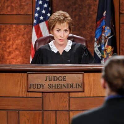 Judge Judy Sheindlin seated at the bench in a courtroom set