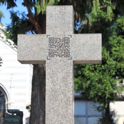 Stone cross headstone featuring a QR code at the center